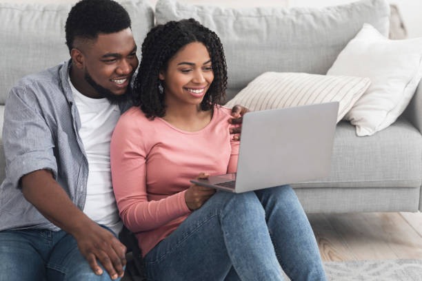 istock Work From Home. Smiling African Couple Using Laptop, Working Online Together 1222200117