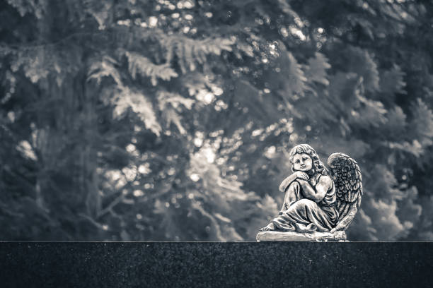 figura de ángel sentada en una vieja lápida en un cementerio. imagen vintage, retro monocroma con espacio de copia. halloween, concepto de fondo de todos los santos - sculpture gothic style grave spooky fotografías e imágenes de stock