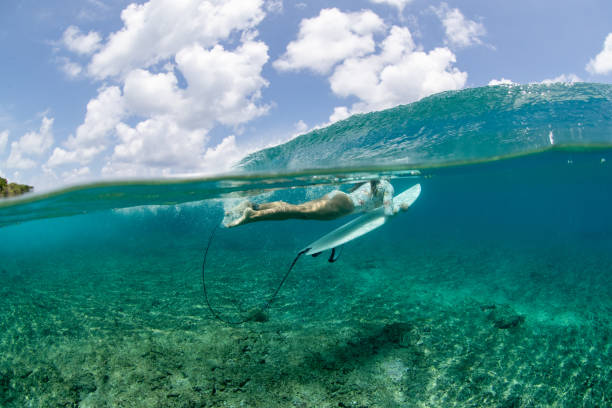 istock Surfer girl duck dives 1222200343