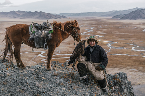 Eagle hunter on the background of river in Gobi desert in Mongolia