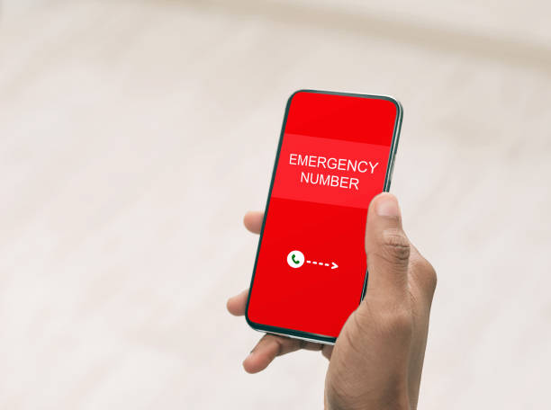 istock Man holding smart phone with emergency number 1222203157