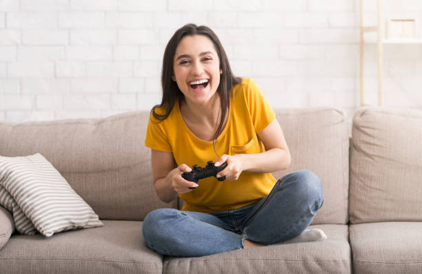 istock Fun stay home pastimes. Excited Hispanic girl with controller playing video games on sofa indoors 1222203281