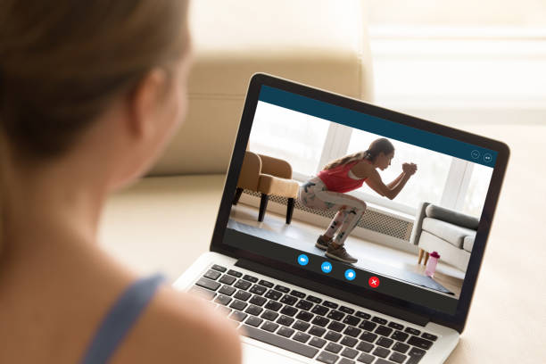 興味のある女の子は、オンライン教育フィットネスワークショップのトレーニングを見て。 - action adult aerobics athlete ストックフォトと画像
