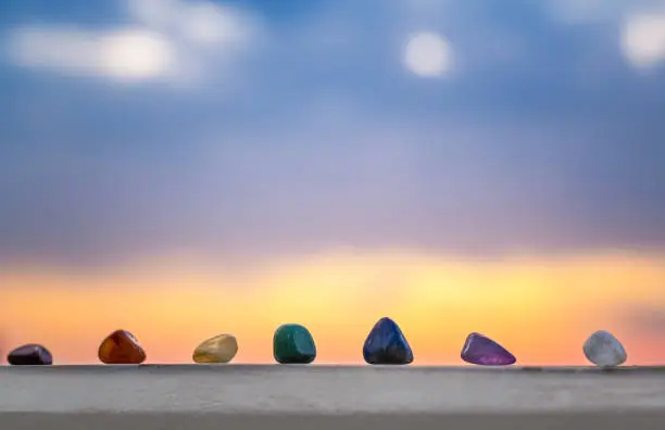 Crystals, energy stones for meditation over sunset background, inner peace, chakra cleansing and balance concept
