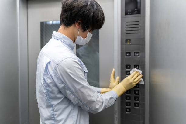 istock Asian man with glove wiping down the elevator button 1222206127