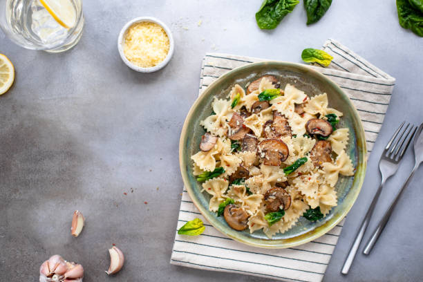 istock Appetizing pasta with mushrooms, spinach and cheese on a gray concrete background. 1222206924