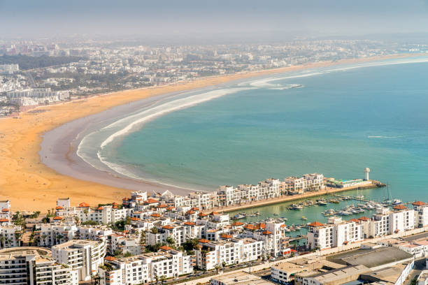 biała nowoczesna architektura otaczająca niezwykle szeroką piaszczystą plażę w agadir, maroko - agadir zdjęcia i obrazy z banku zdjęć
