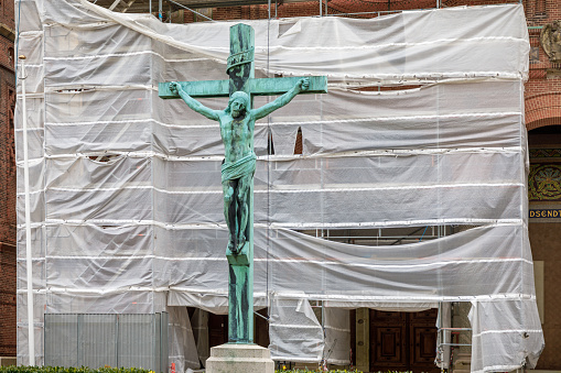 Valby, Copenhagen, Denmark, April 27, 2020: Crucifix in front of a construction site outside Jesus Kirken, which is a famous church in Denmark