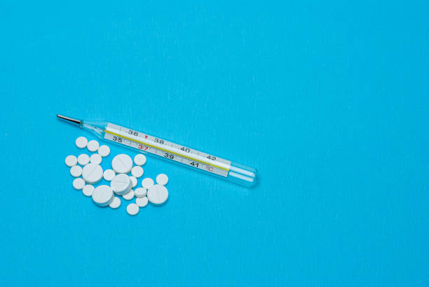 istock White pills and medical thermometer. 1222208628