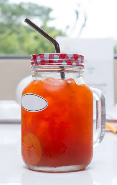 Photo of Iced Lemon tea in jar glass for drink on white table.