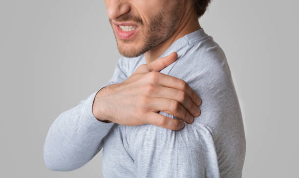 istock Man face expresses pain. Guy has Inflammation in shoulder 1222217242