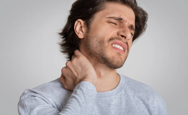 istock Man with painful expression rubs his neck 1222217626