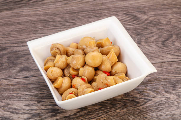 Pickled champignons with spices in the bowl