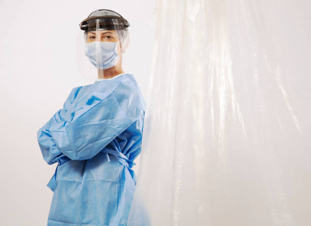 Woman doctor behind isolated curtain Woman doctor behind isolated curtain. The are real hero. welding mask stock pictures, royalty-free photos & images
