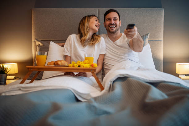 Portrait of happy couple in bedroom,they are having breakfast in bed stock photo