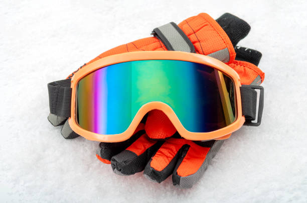 snowboarding and skiing protective gear and winter extreme sports concept with ski goggles and cold weather gloves isolated on white snow background - snow glasses imagens e fotografias de stock
