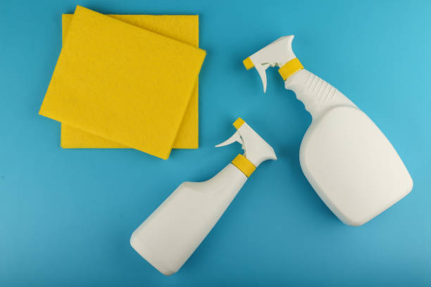 istock white spray bottles detergent and yellow cleaning cloth on blue background flat lay with mock up 1222223375