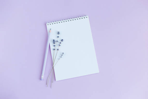 istock Notebook with blank page, pencil and lavander on a violet background. 1222223435