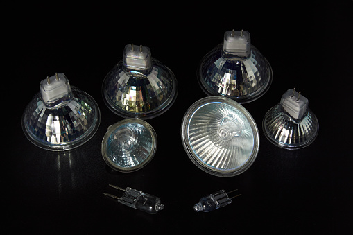 Different types of halogen lamps with and without reflector - close-up on black background