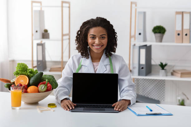 istock Happy female dietologist showing empty laptop screen 1222229076