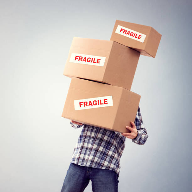 istock Man holding heavy fragile cardboard boxes relocation, moving house or courier delivery 1222229171