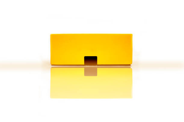 istock Yellow-colored glossy package, parcel, mobile, wrapping box isolated on white background. Box mockup.Side view and horizontal shot with reflection. 1222230075