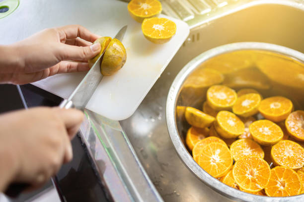 istock Woman cutting oranges for squeezing and making orange juice. 1222230281