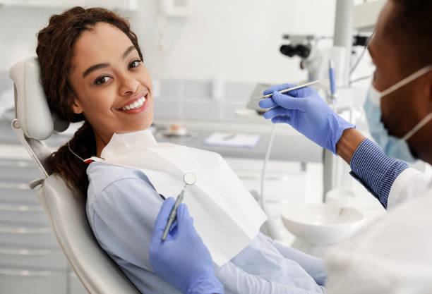 Pretty black woman in dentist chair ready for check up Pretty black happy woman in dentist chair ready for regular check up in modern stomatological clinic dental drill stock pictures, royalty-free photos & images