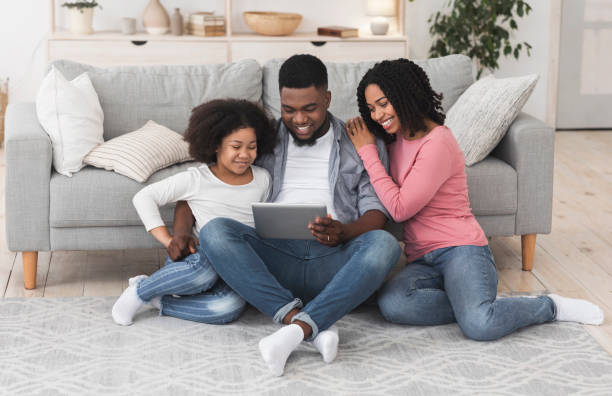 istock Happy Black Parents And Little Daughter Using Digital Tablet At Home 1222230508