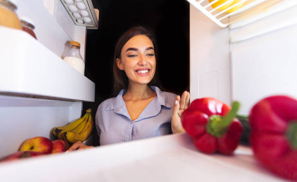 istock Happy woman taking fresh vegetables from fridge 1222230794