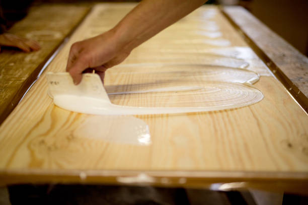 Carpenter glues piece of wood in workshop