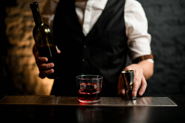 istock Bartender holding steel jigger which stands on bar counter. 1222236178