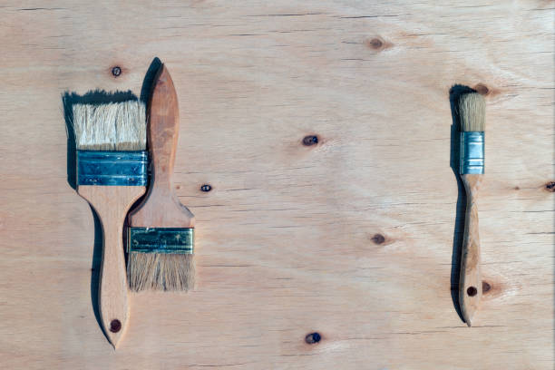 istock Three brushes against wooden plywood background with copyspace. DIY time 1222240964