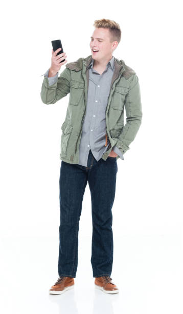 istock Caucasian male standing in front of white background wearing button down shirt and using smart phone 1222241526