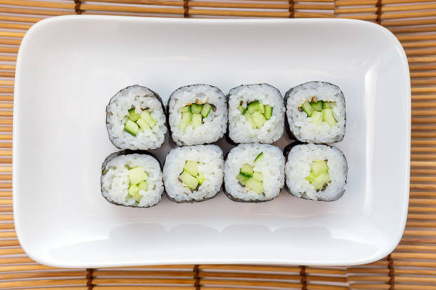 istock Kappa Maki classic roll with cucumber. Hosomaki thin rolls, simple rolls, small rolls, with cucumber. top view on a white plate. 1222241656