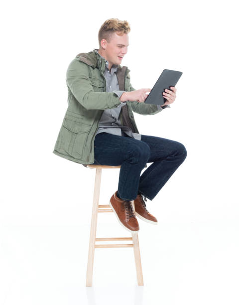 istock Caucasian young male resting in front of white background wearing button down shirt and using digital tablet 1222242121