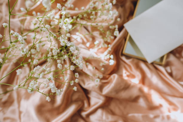 istock White gypsophila flowers on the gold satin fabric. 1222242588