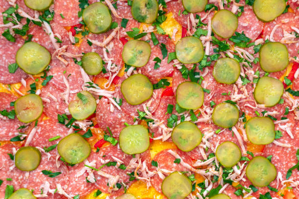 raw ingredients cooking homemade pizza with sausage pepperoni tomatoes, cheese, salami selective orientation. background texture