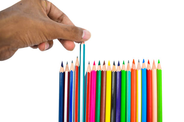 istock Person pulling a blue color pencil crayon from a row of different color pencil crayons 1222242815