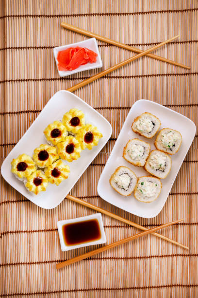 istock tempura Maki sushi rolls with cream cheese, on a white plate close-up. Deep-fried vertical photo. for two persons 1222243017