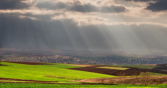 Landscape with a village before the rain.  The sun's rays through the clouds