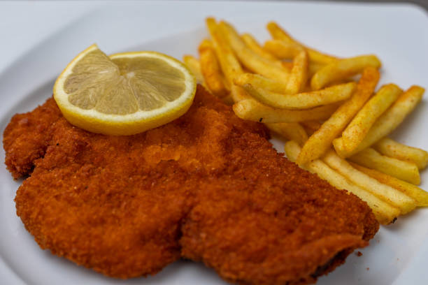 schnitzel vienés empanizado con patatas fritas - viennese schnitzel fotografías e imágenes de stock