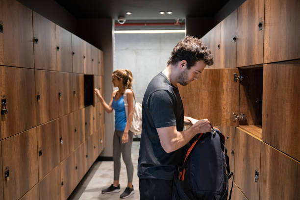 pessoas no vestiário da academia colocando seus pertences no armário - gym locker - fotografias e filmes do acervo