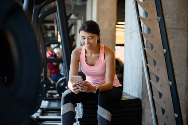 istock Woman at the gym using a mobile app on her phone to see her routine 1222244387