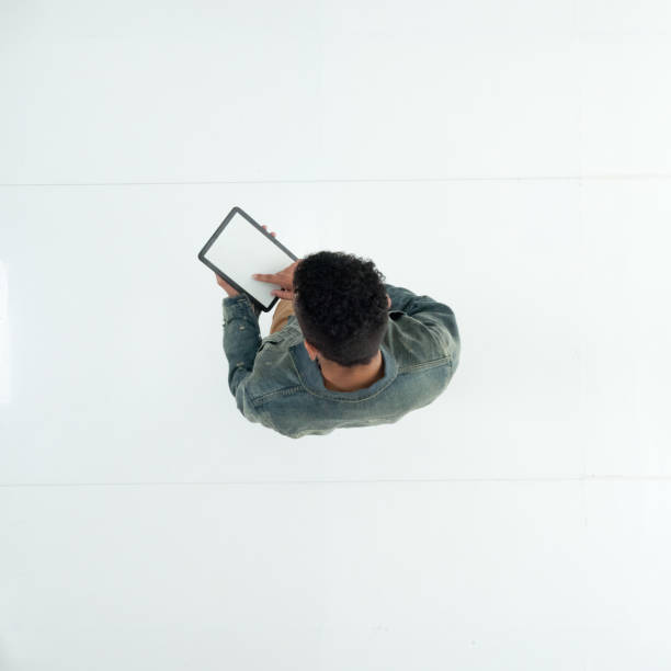 istock Male in front of white background wearing denim jacket and using touch screen 1222244726