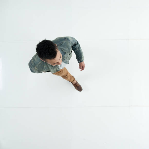 istock Male walking in front of white background wearing denim jacket 1222244802