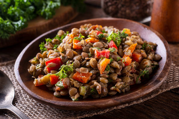 Lentil Salad A bowl of delicious homemade mediterranean lentil salad with lentils, peppers, sun dried tomato and parsley. lentil photos stock pictures, royalty-free photos & images