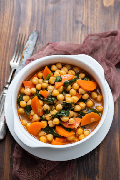 istock chick-pea with carrot and spinach on white bowl on brown wooden backgeound 1222246247