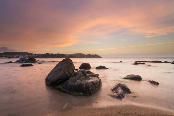 istock Beach with rocks and pink clouds in the sky 1222248143