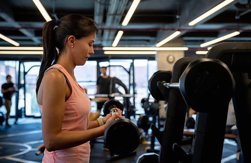 Portrait of an athletic young woman training at the gym using free-weights â fitness concepts